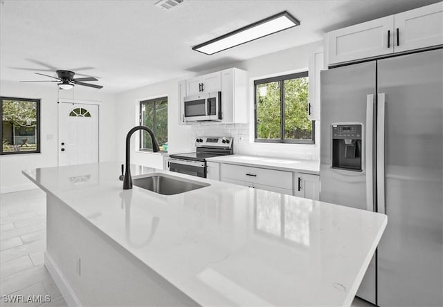 3652 Hibiscus Ave, Naples, FL 34104 - kitchen featuring a ceiling fan, a sink, stainless steel appliances, white cabinets, and decorative backsplash