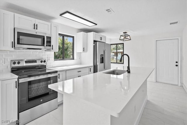 3652 Hibiscus Ave, Naples, FL 34104 - kitchen featuring tasteful backsplash, visible vents, light countertops, stainless steel appliances, and a sink