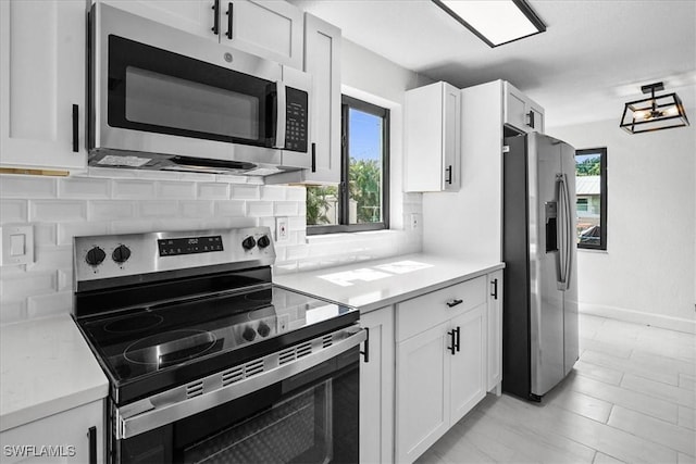 3652 Hibiscus Ave, Naples, FL 34104 - kitchen with decorative backsplash, appliances with stainless steel finishes, white cabinets, and light countertops