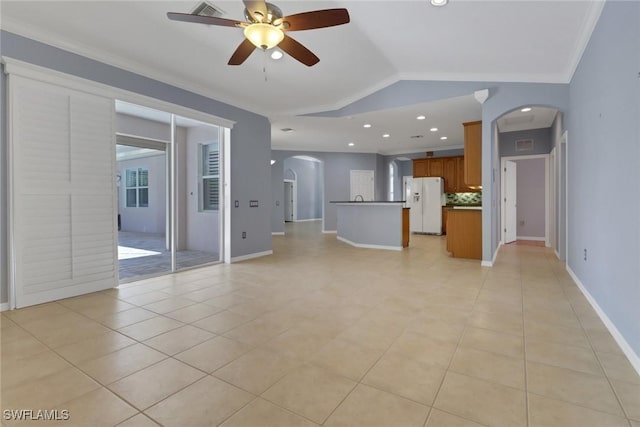 24840 Divot Dr, Bonita Springs, FL 34135 - unfurnished living room featuring arched walkways, ceiling fan, light tile patterned floors, baseboards, and lofted ceiling