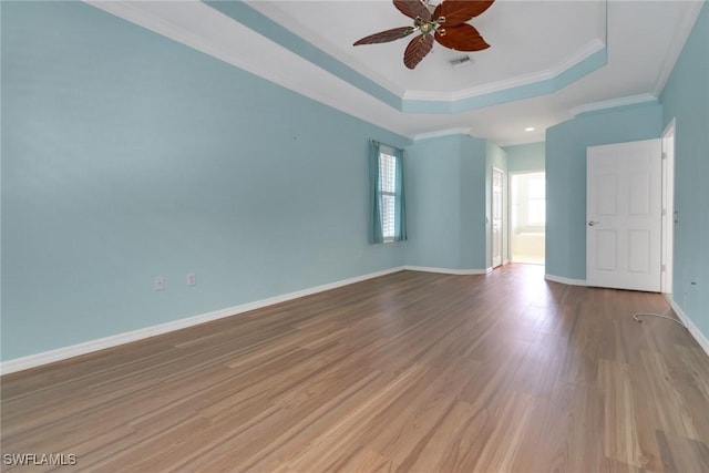24840 Divot Dr, Bonita Springs, FL 34135 - spare room featuring a raised ceiling, a ceiling fan, wood finished floors, crown molding, and baseboards