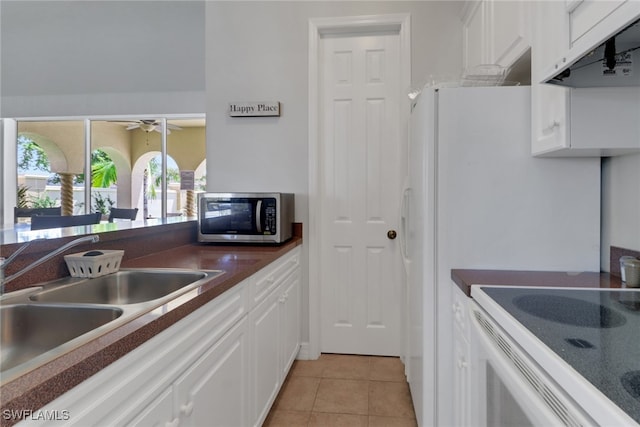 24840 Divot Dr, Bonita Springs, FL 34135 - kitchen featuring stainless steel microwave, ventilation hood, dark countertops, white cabinets, and ceiling fan