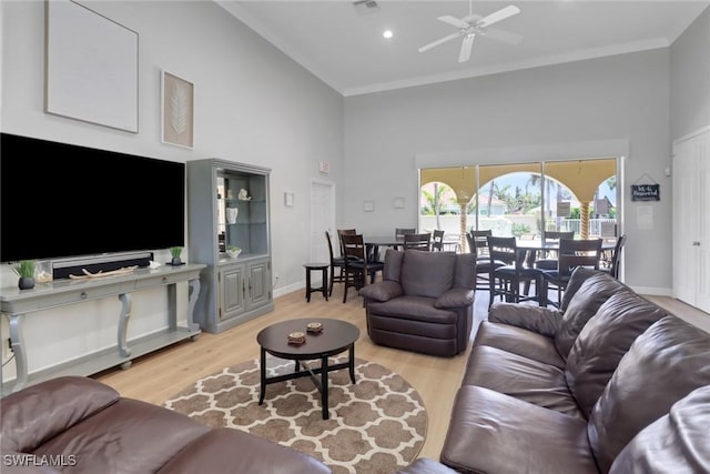 24840 Divot Dr, Bonita Springs, FL 34135 - living room featuring a towering ceiling, ceiling fan, light wood finished floors, crown molding, and baseboards