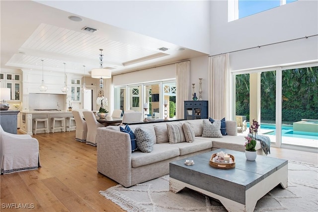living area with visible vents, light wood-type flooring, and wood ceiling