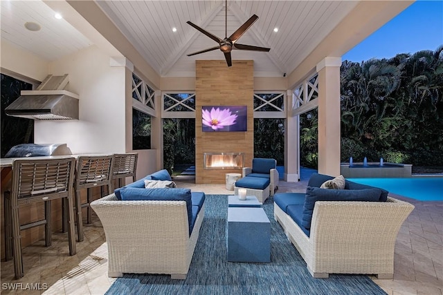 view of patio with area for grilling, ceiling fan, an outdoor living space with a fireplace, and an outdoor pool