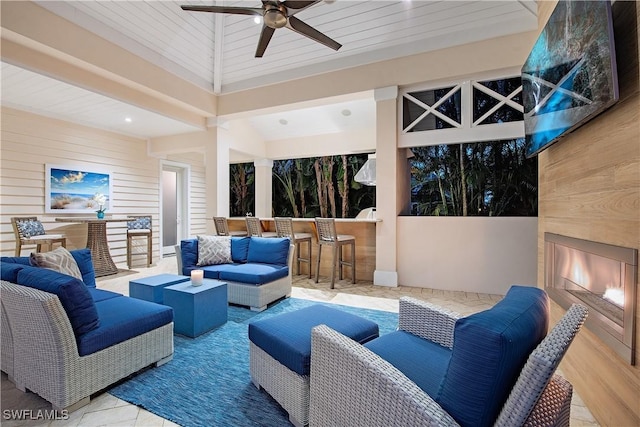 view of patio / terrace with ceiling fan, an outdoor living space with a fireplace, and outdoor dry bar