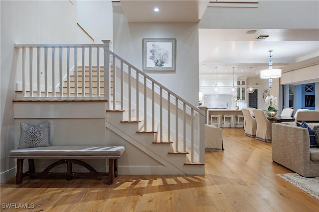 stairs with visible vents, hardwood / wood-style flooring, and recessed lighting