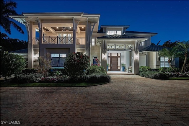 exterior entry at twilight with decorative driveway and a balcony