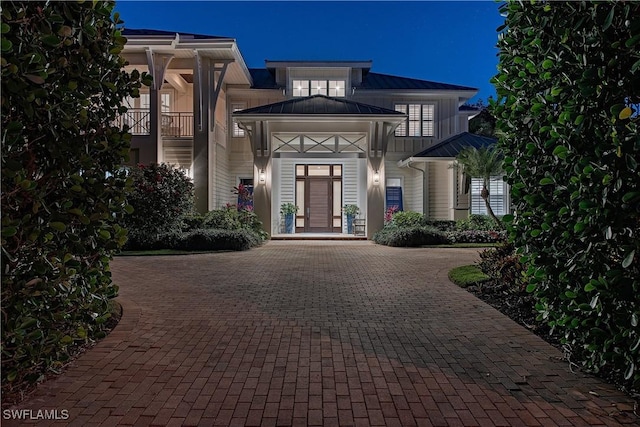 doorway to property with a standing seam roof and curved driveway