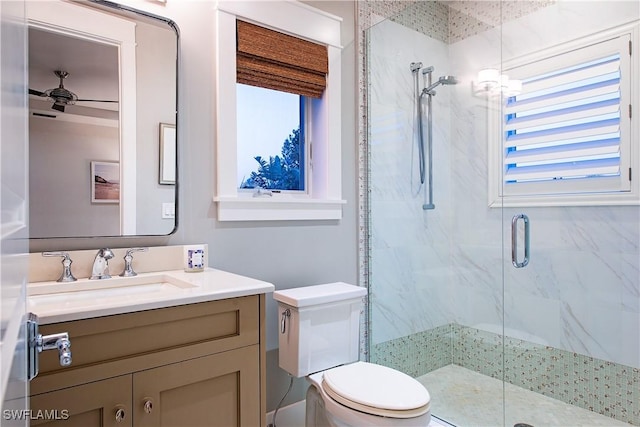 bathroom featuring toilet, a marble finish shower, and vanity
