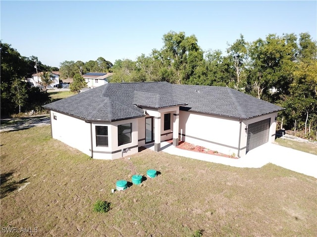 view of front facade with a front lawn, a garage, roof with shingles, and stucco siding