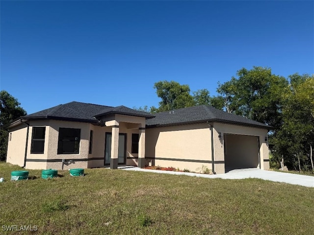 prairie-style house featuring stucco siding, driveway, a front yard, and a garage
