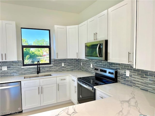 kitchen with a sink, white cabinetry, and stainless steel appliances