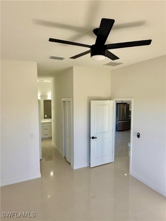 unfurnished bedroom featuring a ceiling fan, baseboards, and freestanding refrigerator