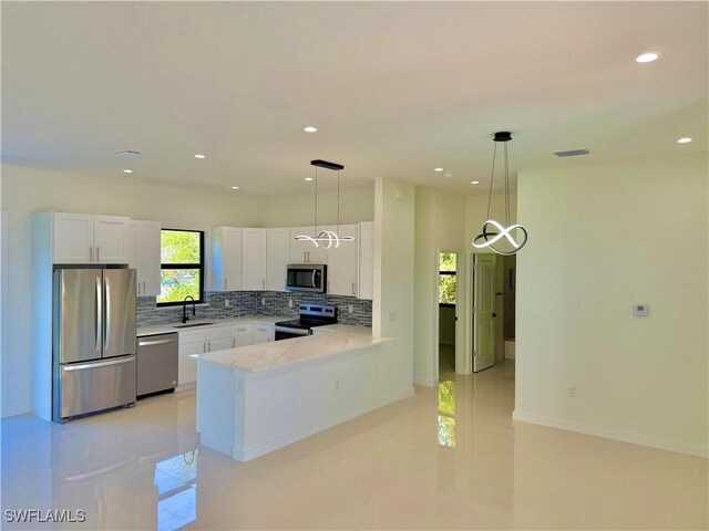 kitchen featuring a sink, stainless steel appliances, a peninsula, and white cabinetry