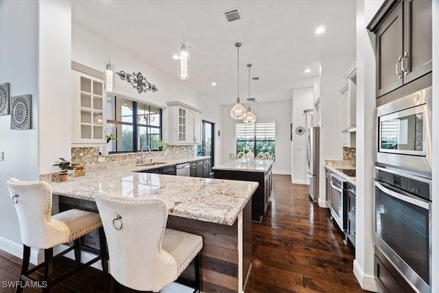 5135 Genoa St, Ave Maria, FL 34142 - kitchen featuring decorative backsplash, dark wood-style flooring, appliances with stainless steel finishes, and a kitchen island