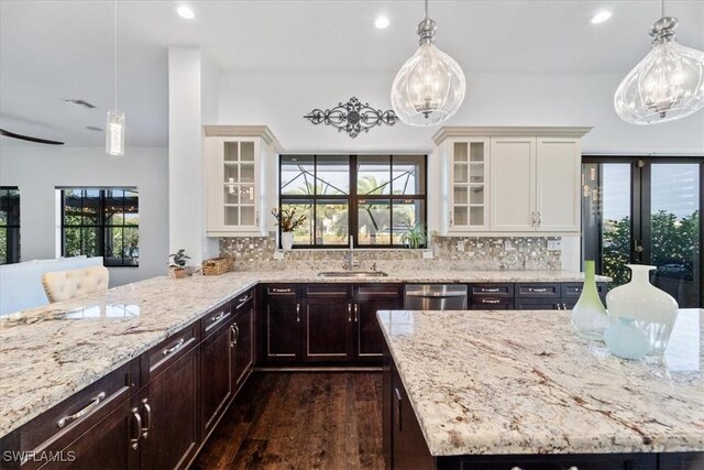 5135 Genoa St, Ave Maria, FL 34142 - kitchen with a sink, light stone counters, white cabinetry, decorative backsplash, and dishwasher