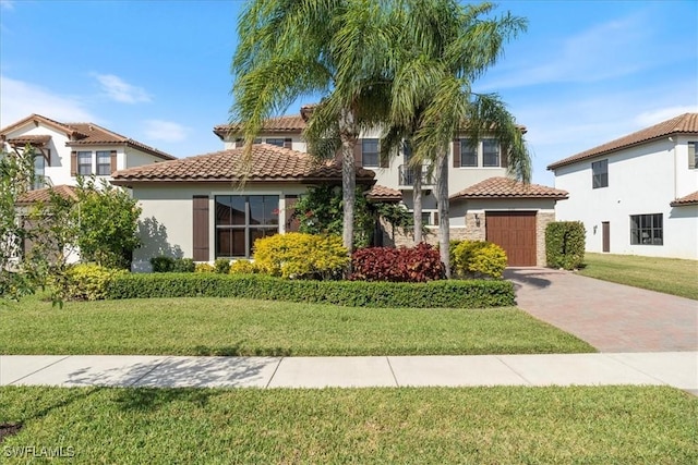 5135 Genoa St, Ave Maria, FL 34142 - mediterranean / spanish home with an attached garage, stucco siding, a front lawn, a tile roof, and decorative driveway
