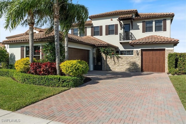 5135 Genoa St, Ave Maria, FL 34142 - mediterranean / spanish-style house featuring a tiled roof, decorative driveway, stone siding, and stucco siding