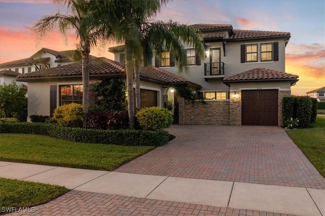 5135 Genoa St, Ave Maria, FL 34142 - mediterranean / spanish house with a tile roof, stucco siding, decorative driveway, a balcony, and stone siding