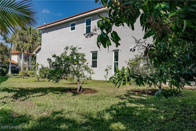 view of home's exterior featuring stucco siding, a yard, and a tile roof