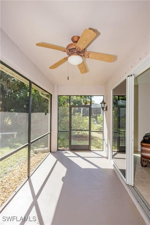 unfurnished sunroom featuring ceiling fan