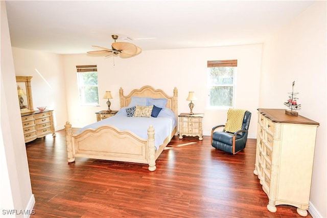 bedroom with dark wood finished floors, visible vents, ceiling fan, and baseboards