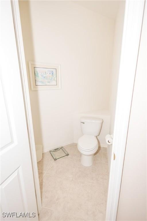 bathroom with tile patterned floors, toilet, and baseboards