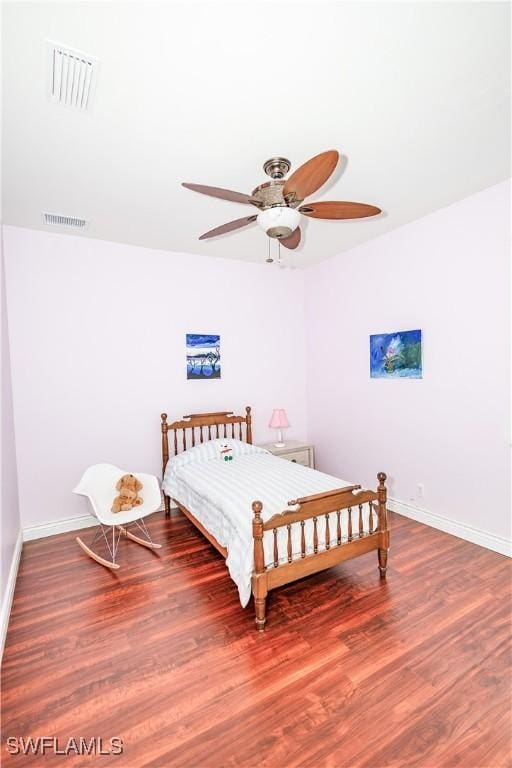 bedroom featuring ceiling fan, visible vents, baseboards, and wood finished floors