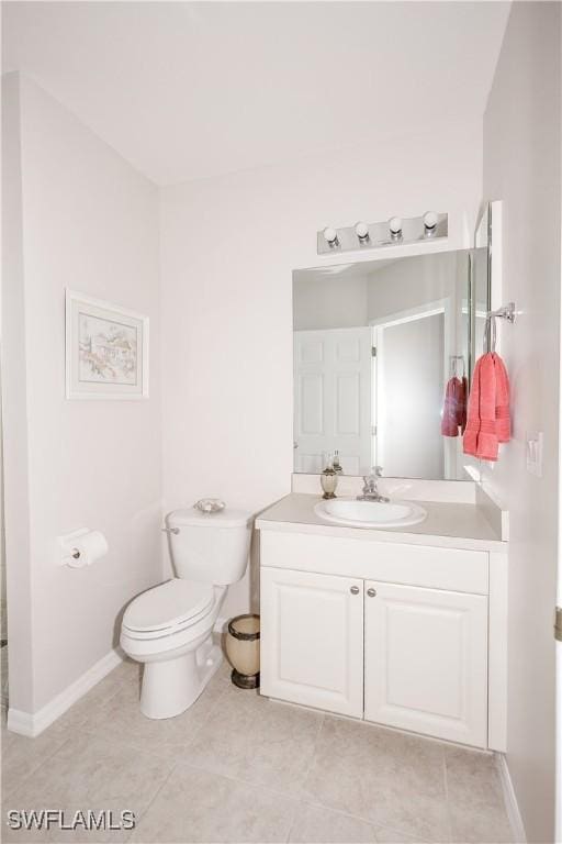 bathroom with vanity, toilet, baseboards, and tile patterned flooring