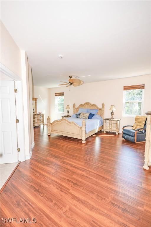 unfurnished bedroom featuring multiple windows, ceiling fan, and wood finished floors