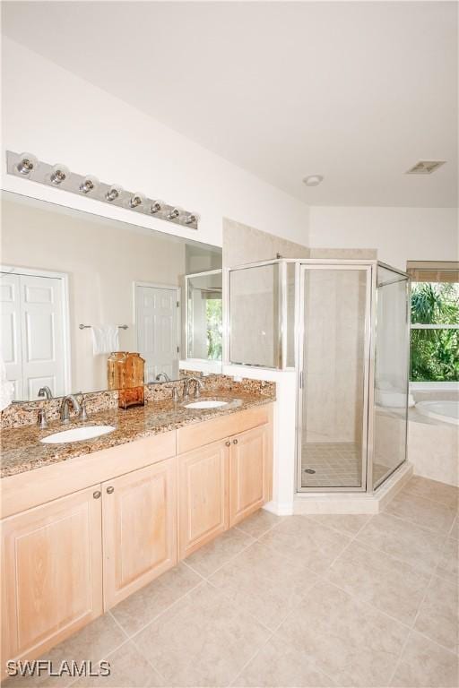 full bathroom with a shower stall, a bath, double vanity, and a sink