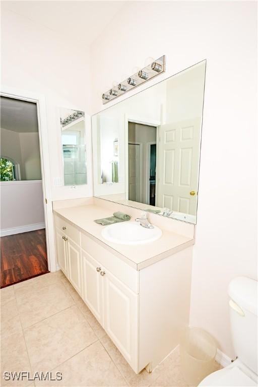 bathroom with tile patterned flooring, toilet, and vanity