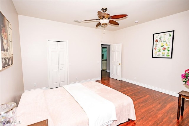 bedroom with a closet, a ceiling fan, baseboards, and dark wood-style flooring