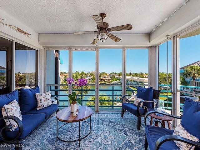 sunroom / solarium with a water view and a textured ceiling