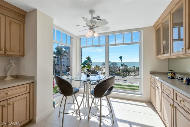 dining area with ceiling fan, baseboards, and light tile patterned flooring