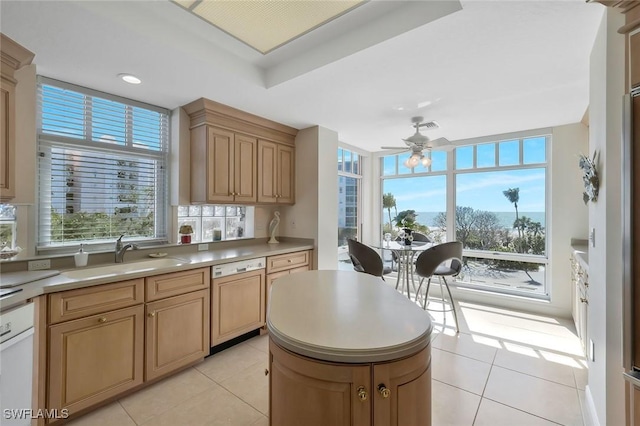 kitchen featuring paneled dishwasher, light tile patterned floors, ceiling fan, a sink, and a wealth of natural light