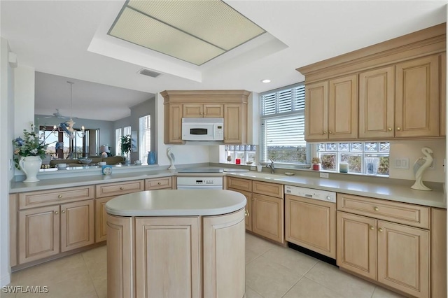 kitchen with white microwave, visible vents, light brown cabinetry, dishwasher, and light countertops