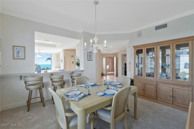 dining room with visible vents, an inviting chandelier, crown molding, baseboards, and light colored carpet
