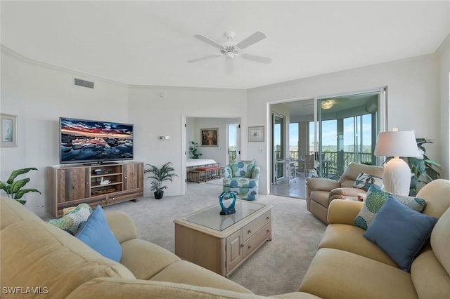 living room featuring visible vents, light colored carpet, and ceiling fan