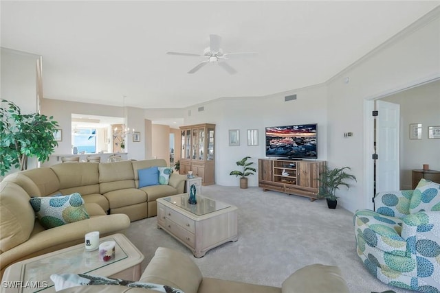 living area featuring visible vents, light colored carpet, crown molding, and ceiling fan