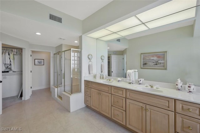 bathroom featuring tile patterned floors, visible vents, a sink, a shower stall, and double vanity