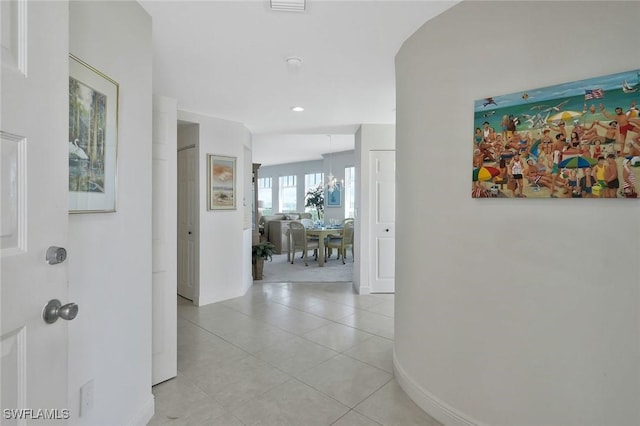 hallway with light tile patterned floors and baseboards