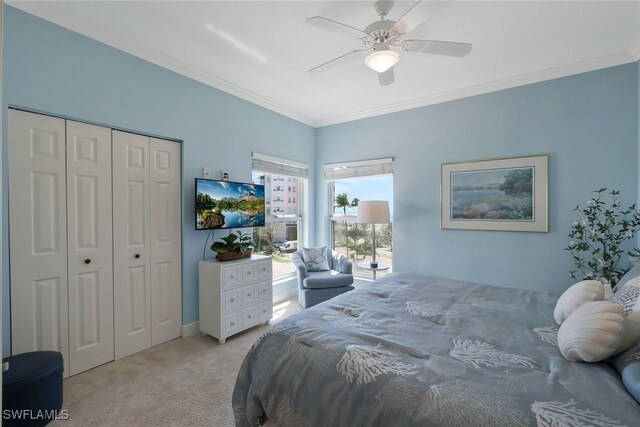 bedroom featuring ceiling fan, crown molding, a closet, and light carpet