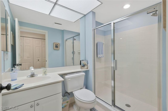 bathroom featuring vanity, a shower stall, and toilet