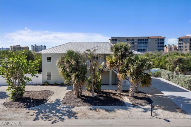 48 Fairview Blvd, Fort Myers Beach, FL 33931 - view of front of house with fence, stucco siding, a standing seam roof, and metal roof
