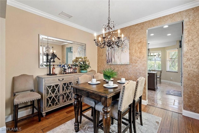 dining area featuring recessed lighting, an inviting chandelier, baseboards, visible vents, and crown molding
