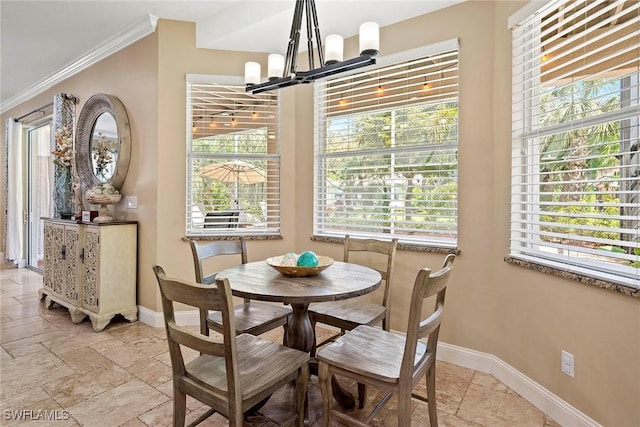 dining area with ornamental molding, a notable chandelier, stone tile floors, and baseboards