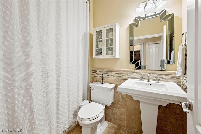 full bathroom with tile walls, curtained shower, toilet, and tile patterned flooring