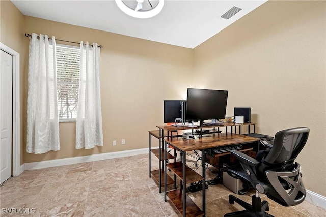 office space featuring stone finish flooring, visible vents, and baseboards